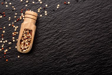 Ahşap kepçe içinde kırmızı, beyaz ve kahverengi kinoa karışımı. Sağlıklı ve diyet süper gıda ürünü. Pankart, menü, tarif, mesaj için yer. en üstteki görünüm.