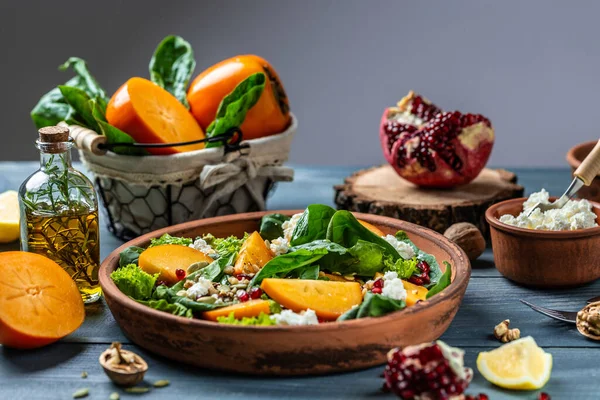 ほうれん草と柿のサラダ ナッツ ヤギチーズ ザクロ カボチャの種 健康的なベジタリアン料理のコンセプト — ストック写真