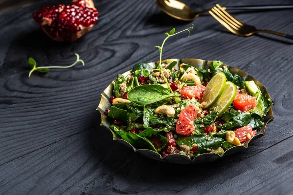 Winter Salad with quinoa, spinach, avocado, grapefruit, pomegranate nuts and microgreens, Vegan detox bowl.