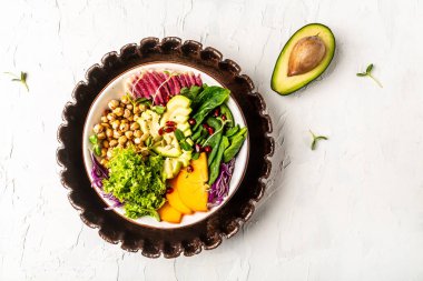 Kızarmış nohut, avokado, hurma, ıspanak, avokado, karpuz turpu ve tohumlu Buda kasesi. Üst görünüm, düz görünüm, kopyalama alanı.