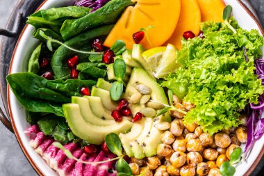 Sağlıklı salata vegan, kavrulmuş nohut, avokado, hurma, ıspanak, avokado, karpuz turpu ve çekirdekli detoks yemeği. Üst manzara, düz uzanma.