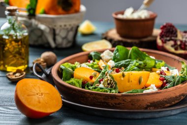 Hurma, ıspanak, fındık, keçi peyniri, nar ve balkabağı tohumlu sağlıklı salata. Spor yemeği. Superfood Vitamin Sonbahar hurma salatası. Sağlıklı yemek..