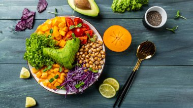 Vegan, detoks Buda kasesi avokado, domates, kırmızı lahana, nohut, taze salata, balkabağı, hurma. Sağlıklı vejetaryen gıda konsepti.
