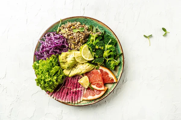 Trendy salad with quinoa, micro greens, avocado, grapefruit, broccoli, watermelon radish, red cabbage. Restaurant menu dieting, cookbook recipe. Top view flat lay, copy space.