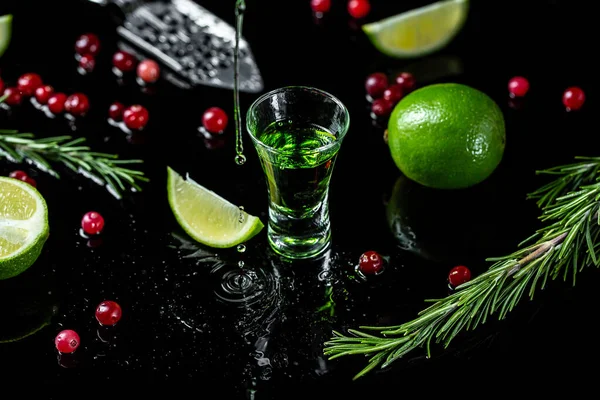 Alcoholic drink, pouring absinthe over a sugar cube in a stainless steel spoon, sugar and cranberries are scattered nearby, freeze motion.