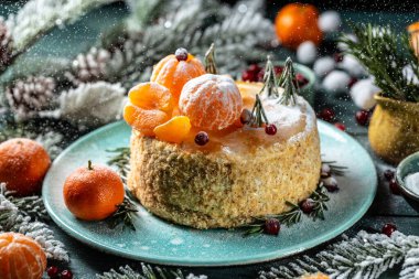 Noel ve kışın ballı pasta, mandalinalarla süslenmiş, Noel ağacı şeklinde biberiye, kar gibi serpiştirilmiş toz, atmosferik fotoğraf.