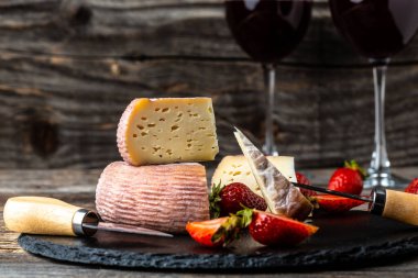 Kilerinde kırmızı şarap bulunan çeşitli peynirler..