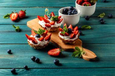 Çilekli vanilyalı krem peynirli tart ve tidewater yeşili arka plan. Yemek tarifi geçmişi. Kapat..