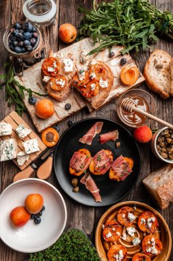 Mavi peynirli, şeftalili, jambonlu ve roka arkaplanlı gurme salatası. Pankart. Üst Manzara. dikey resim.