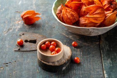 Tahta kütüğün üzerinde Physalis. Sonbahar kırmızı fisalis meyvesinin olgun meyveleri. Meyve. Physalis veya Çin Fener Bitkileri.