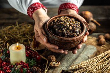 Kutya törensel bir tahıl tabağı. Slav gömlekli bir adam geleneksel kutia ile kase tutuyor. Ukrayna, Belarus ve Polonya 'da Noel yemeği. Noel yemeği kutia.