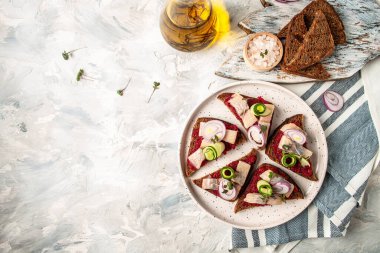 Ringa filetosu. Tuzlu ringa balıklı sandviç, pancar kökü, yeşil salatalık, soğan ve kızarmış ekmek. İskandinav mutfağı. Geleneksel Danimarka sandviçi. en üstteki görünüm.