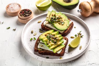 Avokado tostları çavdar ekmeği, dilimlenmiş avokado, balkabağı ve susam tohumu, tuz ve biber. Vejetaryen sandviçleri lezzetli kahvaltı ya da atıştırmalık.