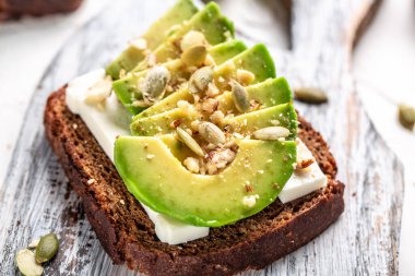 Kahvaltıda ya da öğle yemeğinde avakado ve keçi peynirli çavdar ekmeği sandviçi. Vejetaryen yemeği. Temiz yemek..