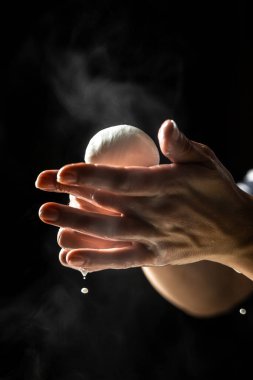 Mozarella peynirinin üretim süreci. Küçük bir aile mandırasında çalışan bir kadın peynir yapmanın son adımlarını işliyor. Geleneksel İtalyan mozzarellası.