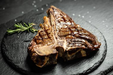 Orta pişmiş ızgara T-Bone Bifteği, ızgara yıllanmış wagyu bifteği sulu, az pişmiş ve arka planda baharatlı biftek. Yemek tarifi geçmişi. Kapat..