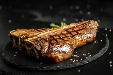 T-bone ya da yıllanmış wagyu biftek ızgara biftek baharat ve bitkilerle. Orta pişmiş ızgara T-Bone bifteği, ızgara eskimiş wagyu bifteği..