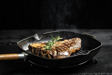 Kızartma tavasında biftek pişiriyorum. Yemek tarifi geçmişi. T-bone ya da yıllanmış wagyu bifteği ızgarası. Metin için boşluk.