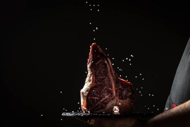 Çiğ, yıllanmış wagyu bifteği ve büyük parça fileto. Pişirmeye hazır. Dondurucu hareketle siyaha tuz serpmek için pişirilmiş el. menü restoranı veya tarif metni için.