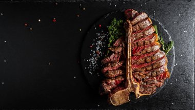 Barbekü kurutulmuş wagyu bifteği, ızgara orta pişmiş biftek ve tahtada servis edilen baharatlar. Kesilmiş. Uzun pankart biçimi, üst görünüm.