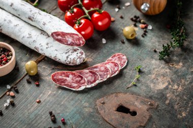 Fuet Salami dilimlere ayrılmış. Klasik ahşap arka planda geleneksel İspanyol sosisi. Pankart, yemek servisi menü tarifi yeri, metin, üst görünüm.