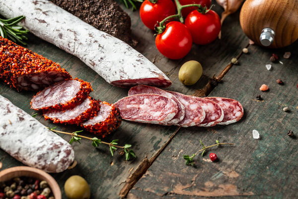 Spanish tapas sliced sausages salami, fuet and chorizo on a wooden background. Traditional Spanish sausage. banner, catering menu recipe place for text, top view.