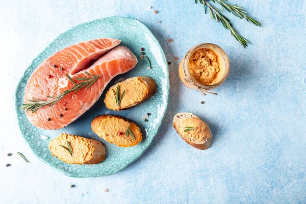 Smoked Salmon, mousse, pate and toasts on a ceramic plate, blue background, Jewish cuisine restaurant dish menu, dieting, cookbook recipe.