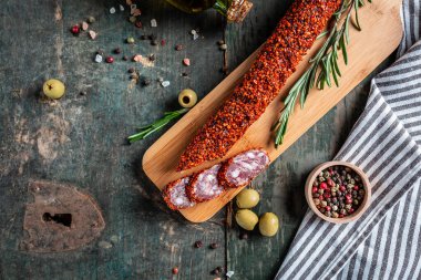 Baharatlı salam sucuklu sosis ve ahşap masanın üzerinde sarımsak. Geleneksel İspanyol sosisi. afiş, menü tarifi, üst görünüm.