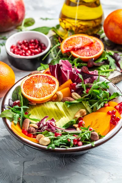 Vegan, detoks Buddha kasesi avokado, hurma, kan portakalı, fındık, ıspanak, roka ve nar. Sağlıklı dengeli beslenme. Üst Manzara. dikey resim