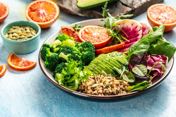 Insalata di quinoa con verdure, avocado, arancia rossa, broccoli, ravanello all'anguria, spinaci, semi di zucca. Ricetta cibo sfondo. Da vicino. — Foto Stock