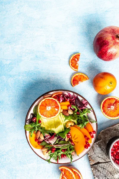 Чиста концепція здорового харчування. Миска Будди з авокадо, кров'яним апельсином, броколі, редькою кавуна, шпинатом, кіокою, гарбузовим насінням на синьому фоні. вертикальне зображення, місце для тексту — стокове фото