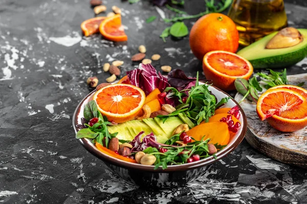 Πιάτο μπολ του Βούδα με αβοκάντο, λωτό, ματωμένο πορτοκάλι, ξηρούς καρπούς, σπανάκι, ρόκα και ρόδι. Υγιεινή ισορροπημένη διατροφή. Άνω όψη — Φωτογραφία Αρχείου