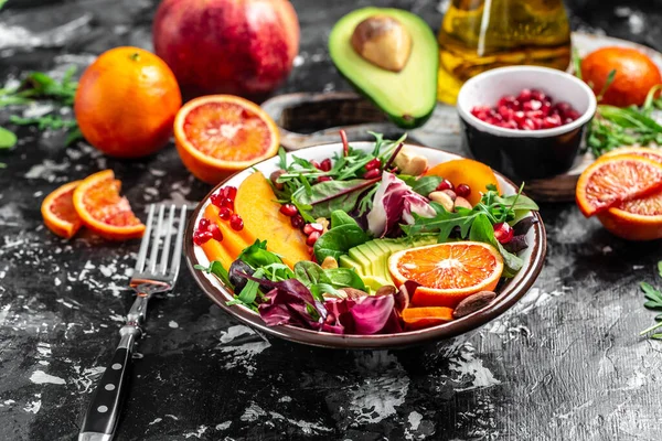 Vegan, recette de bol de Bouddha de désintoxication avocat, kaki, orange sanguine, noix, épinards, roquette et grenade sur un fond clair, vue dessus — Photo