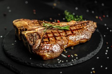 T-bone ya da yıllanmış wagyu biftek ızgara biftek baharat ve bitkilerle. Orta pişmiş ızgara T-Bone bifteği, ızgara eskimiş wagyu bifteği..