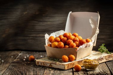 Patates kroketleri patates püresi, ekmek ve kızarmış patates topları, ahşap masada karton kutuda servis ediliyor. Amerikan gıda konsepti. Fast food yemeği. pankart, menü, tarif, metin için yer.