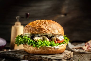 Tahta tahtada servis edilen hardallı, zeytinli ve kremalı tavuk burgerleri. Amerikan gıda konsepti. Fast food yemeği. pankart, menü, tarif, metin için yer.