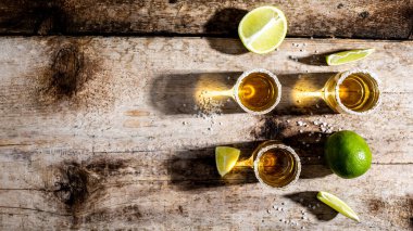 Limonlu ve ahşap masadaki tuzlu bardakta tekila. konsept lüks içecek. Alkolik içki. Metin için boşluk. Uzun pankart biçimi.