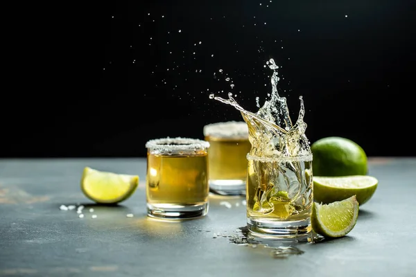 Mexican tequila with lime and salt on stone background. concept luxury drink. Alcoholic drink. Freeze motion, drops in liquid splash Mexican national drink. space for text.