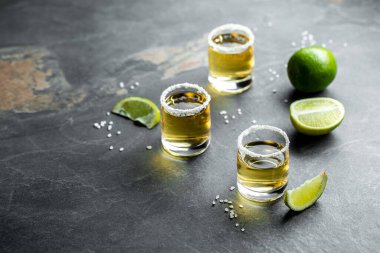 Taş zemin üzerinde limon ve tuz olan Meksika Altın Tekilası. konsept lüks içecek. Alkolik içki. metin için yer.