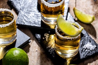 Limonlu Meksika tekilası ve siyah arka planda tuz. Metin için boşluk. konsept lüks içecek. Alkolik içki.
