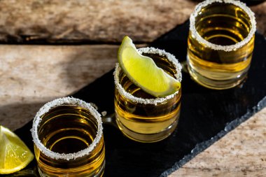 Tuzlu tekila shot ve limonlu Meksika milli içkisi. Altın tekila shot 'ları. Meksika ulusal içkisi. en üstteki görünüm.