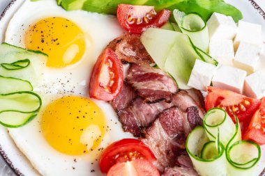 Yumurta, avokado, domates, pastırma ve peynirli keto kahvaltısı. Sağlıklı besleyici paleo keto kahvaltı konsepti. en üstteki görünüm.