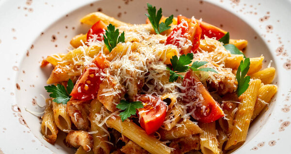Pasta Penne with Tomato Bolognese Sauce, chicken meat, Parmesan Cheese. Italian food. Food recipe background. Close up.