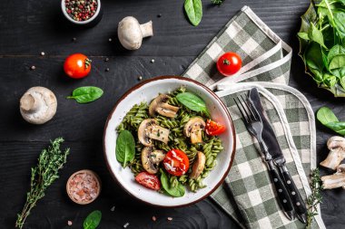 Ispanaklı vejetaryen yeşil makarna, şampiyon mantarlar, vişneli domatesler. Vejetaryen sağlıklı yiyecekler. afiş, metin için menü tarifi yeri, üst görünüm.