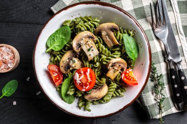 Ispanaklı vejetaryen makarna, mantar mantarı, vişneli domates. Vegan gıda konsepti. en üstteki görünüm.