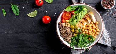 Karalahana salatası, kinoa, tavuk filetosu, nohut, avokado, ıspanak, domates kirazı, fındık roka, temiz beslenme konsepti. Uzun afiş biçimi. en üstteki görünüm.