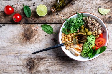 Karalahana salatası, kinoa, tavuk filetosu, nohut, avokado, ıspanak, domates kirazı, fındık roka, temiz beslenme konsepti. en üstteki görünüm.