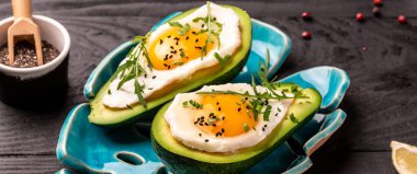 Yumurtalı avokado, siyah arka planda taze maydanoz, afiş, metin için menü tarifi yeri, üst görünüm.