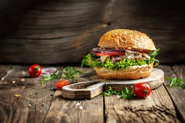 Ahşap arka planda roka ve küflü peynirli gurme burger. Fast food ve abur cubur kavramı.