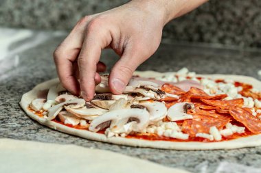 Closeup hand of chef baker making pizza at kitchen. The process of making pizza. Hands preparing a pizza.